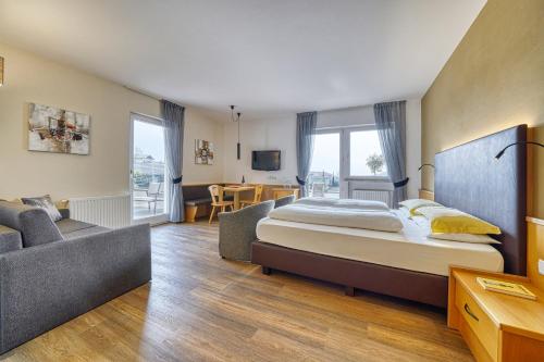 a bedroom with a bed and a couch and a table at Das Mitterplarser Hotel in Lagundo