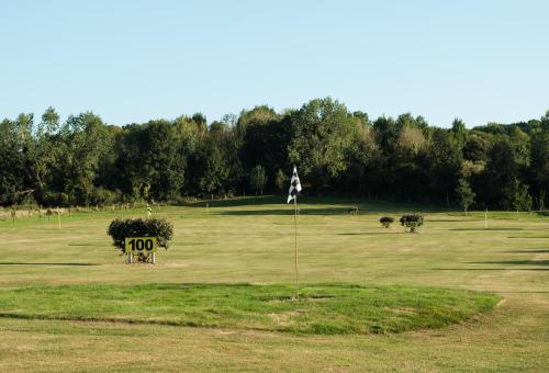 een golfbaan met een vlag in het midden van een veld bij Domaine du Lieu des Brocs - Country Club in Brucourt