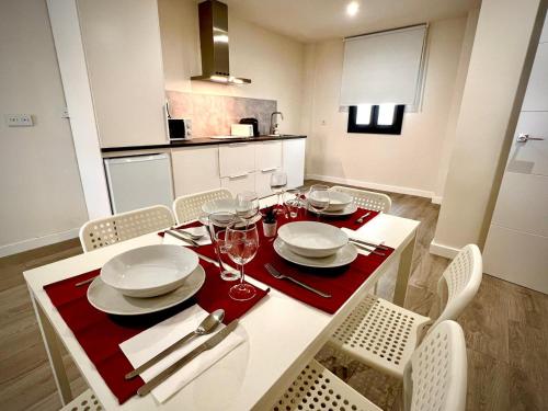 una mesa de comedor con platos y copas de vino en Apartamento Jazmín en Córdoba