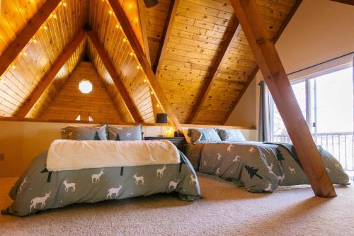a bedroom with two beds in a attic at Furnished Deck + Fire Pit: Happy Jack Cabin in Happy Jack