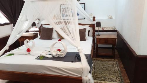 1 dormitorio con 1 cama con mosquiteras blancas en Belle Des Iles, en La Digue