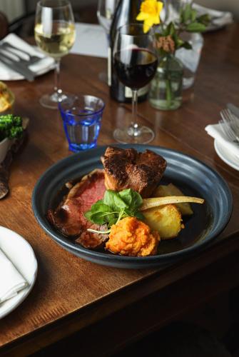 un plato de comida con carne y verduras en una mesa en The Bruce Arms, en Ripon