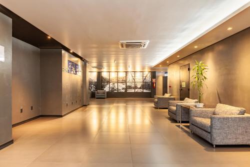 um corredor com sofás e cadeiras num edifício em Tri Hotel Executive Lajeado em Lajeado