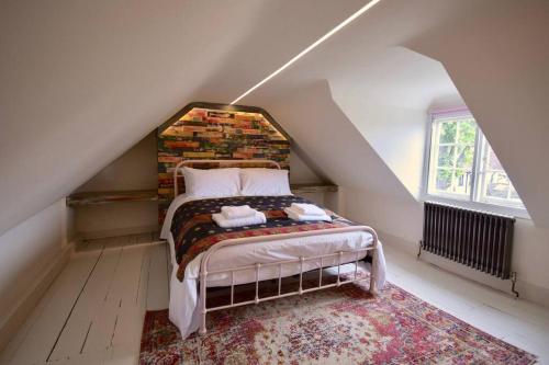 a bedroom with a bed with a brick wall at HAVELI in WINCHELSEA in Winchelsea
