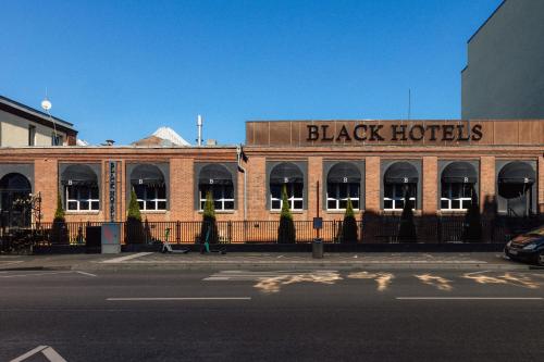 a building with a black hotel on the side of a street at Black Hotels Köln in Cologne