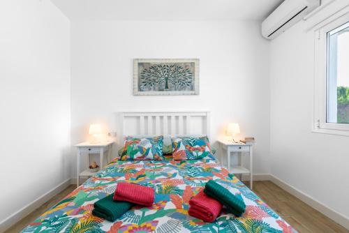 a bedroom with a bed with colorful pillows on it at La Casa del Campo de Mis Rapaciños in Alhaurín el Grande