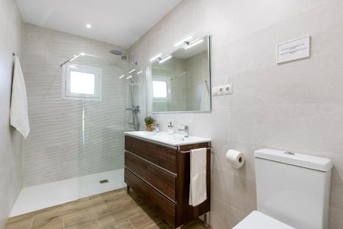 a bathroom with a sink and a toilet and a mirror at La Casa del Campo de Mis Rapaciños in Alhaurín el Grande