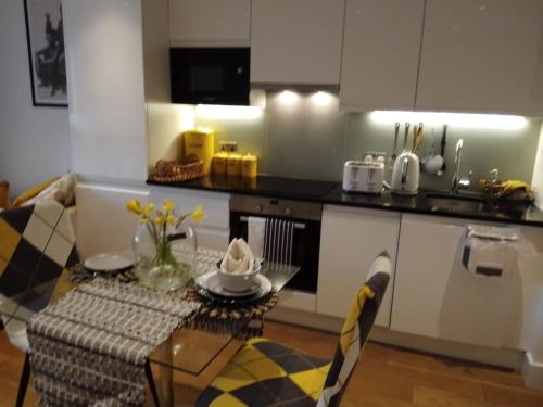 a small kitchen with a table and a kitchen counter at Whole apartment 5 mins to East Croydon & concierge in London