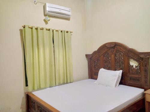 1 dormitorio con 1 cama con cortina verde en Deeva Homestay Syariah RedPartner, en Kota Bawah Timur