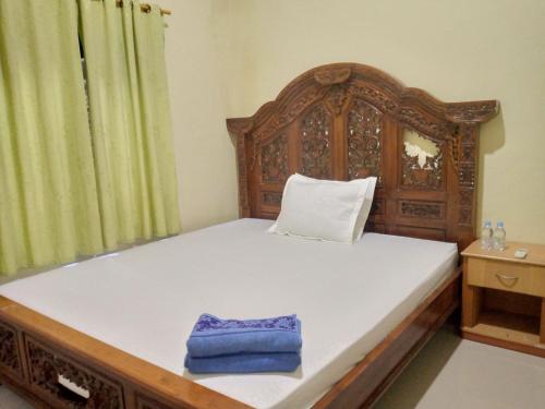 a bedroom with a wooden bed with a blue towel on it at Deeva Homestay Syariah RedPartner in Kota Bawah Timur