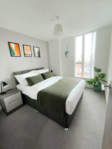 a bedroom with a large bed and a large window at The Panda - Modern 2 Bedroom Apt in Manchester City Centre in Manchester