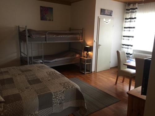 a bedroom with two bunk beds and a desk at Sauerland-Hotel in Essentho