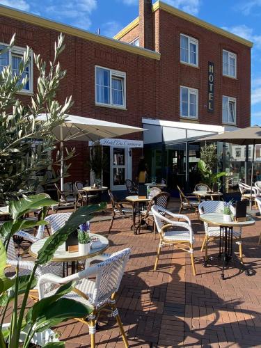 a patio with tables and chairs in front of a building at Hotel Du Commerce in Oostburg