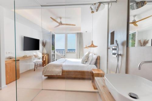 a bedroom with a bed and a bathroom with a tub at Maya Beach Resort in Massa Lubrense