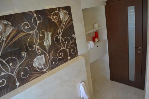 a bathroom with a wall mural of flowers on the wall at Aquangar in Cehu Silvaniei