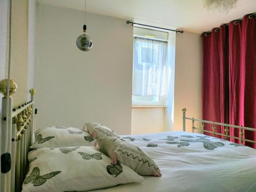 une chambre avec un lit avec des oreillers et une fenêtre dans l'établissement Au bord de l'eau à ConcarnOLoc, à Concarneau