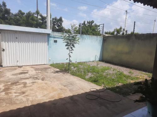 a yard with a fence and a building at Linda casa com 2 quartos, um com ar e outro com ventilador, e garagem in Parnaíba