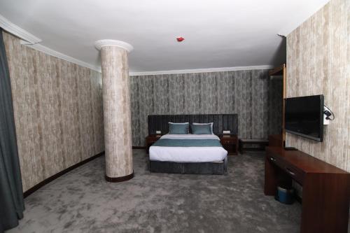 a hotel room with a bed and a column at SARDUR HOTEL in Bostaniçi