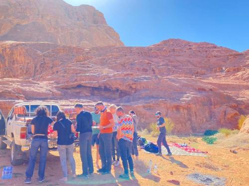 a group of people standing around in the desert at Rum ROZA Luxury Camp in Wadi Rum