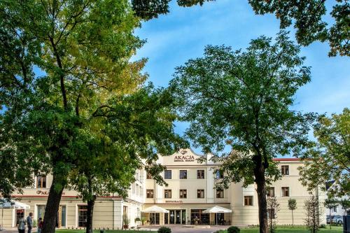 a large white building with trees in front of it at Akacja Medical Resort in Ciechocinek