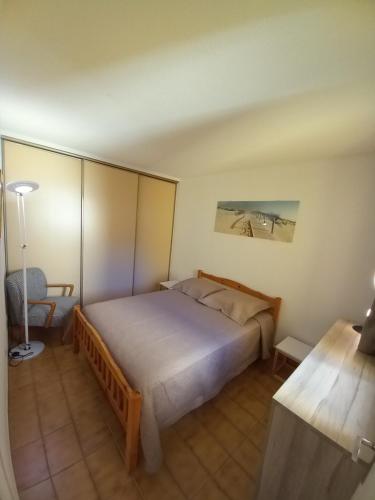 a bedroom with a large bed and a desk at Hélios 24, T2 climatisé, parking, terrasse, 500m plage in Cap d'Agde