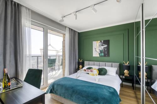 sypialnia z zielonymi ścianami, łóżkiem i biurkiem w obiekcie Horyzont 115 w Warszawie