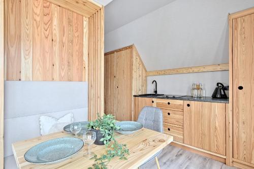 a dining room with a table and a kitchen at Harda House Friends & Spa in Zakopane