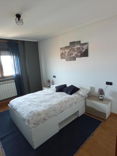 a bedroom with a white bed and a window at VuT EL NEGRILLO 15 VUT-LE-413 in Astorga
