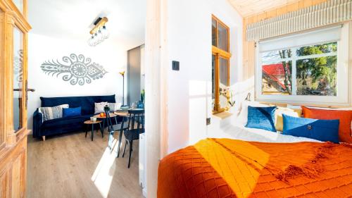 HELLO Apartamenty - Pozytywka z widokiem na Śnieżkę في كارباش: غرفة نوم بسرير واريكة وطاولة