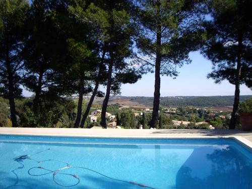 - une piscine bleue avec vue sur les arbres dans l'établissement appartement avec vue panoramique, à Combaillaux