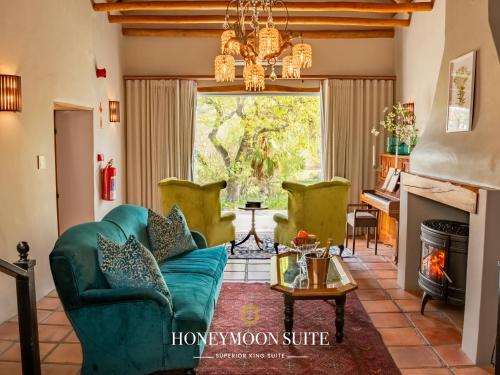 a living room with a blue couch and a fireplace at Tulbagh Boutique Heritage Hotel in Tulbagh