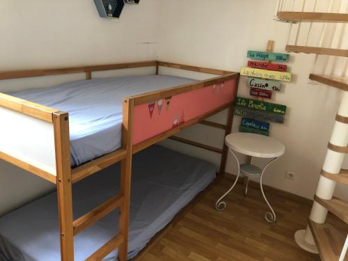 a bunk bed with a desk and a chair in a room at Maison de pêcheur située dans une impasse privée à 300 m de la mer in Les Sables-dʼOlonne