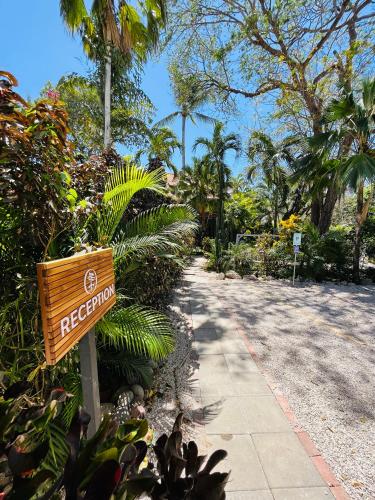 a sign for a resort on the side of a sidewalk at Hotel El Manglar in Playa Grande