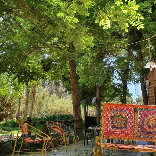 a group of chairs and tables under a tree at Rancho Por Fin in Barreal