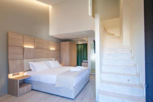 a bedroom with a bed and a staircase at ALTHAEA LUXURY ROOMS in Skiathos