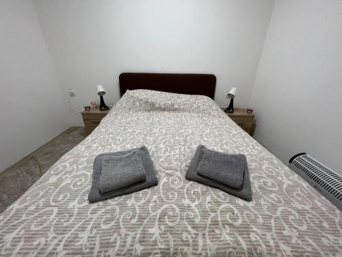 a bedroom with a bed with two pillows on it at Aurora apartment in Sombor