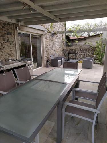 une table et des chaises assises sur une terrasse dans l'établissement Loft au calme dans une ancienne grange béarnaise, à Verdets