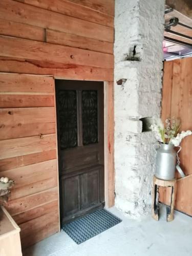 d'une porte en bois d'un bâtiment avec un pot à côté de celui-ci dans l'établissement Loft au calme dans une ancienne grange béarnaise, à Verdets