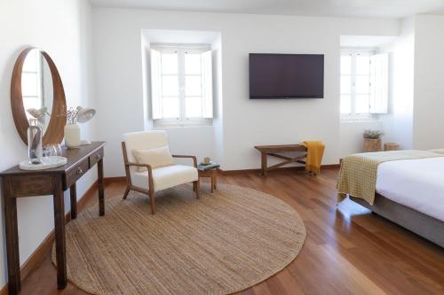 a bedroom with a bed and a desk and a mirror at Casa do Gadanha in Estremoz