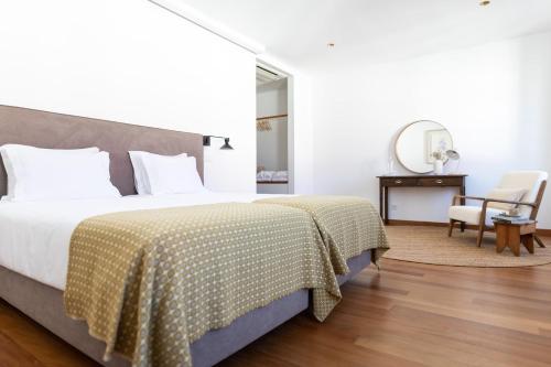 a bedroom with a bed and a desk and a chair at Casa do Gadanha in Estremoz
