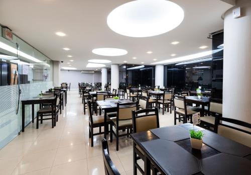 a dining room with tables and chairs in a restaurant at Centromar Hotel in Balneário Camboriú