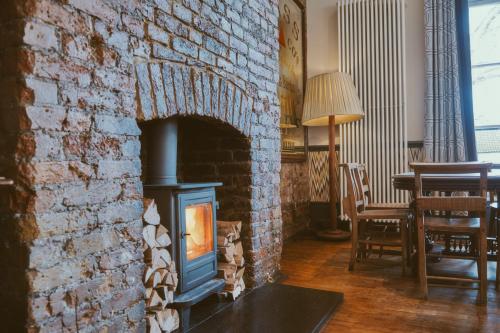 a brick wall with a stove in a room with a table at The Brownswood in London