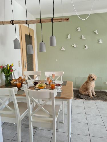 a dog sitting on a rug next to a dining room table at Watt will man Meer in Cuxhaven