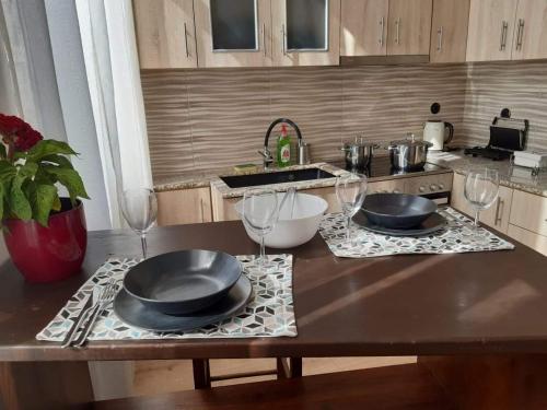 a kitchen with two plates and wine glasses on a counter at LaZaRTe in Mytilini