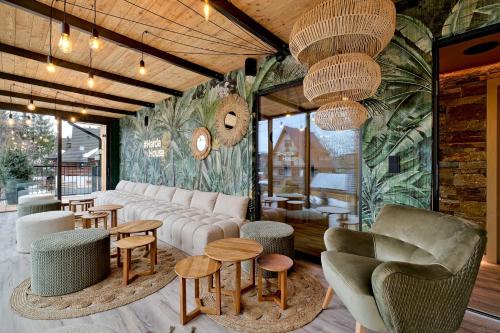 a lobby with a couch and tables and chairs at Harda House Friends & Spa in Zakopane