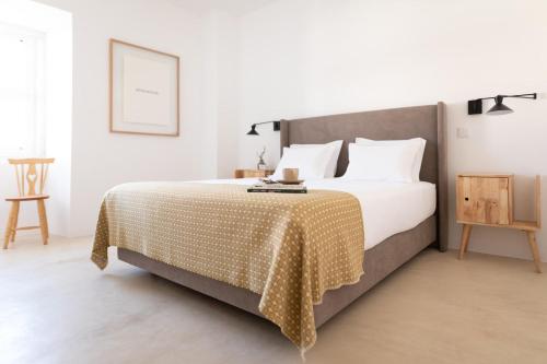 a bedroom with a bed with a blanket on it at Casa do Gadanha in Estremoz