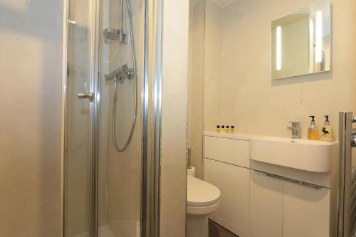 a bathroom with a shower and a toilet and a sink at The Blue Bell Inn in Kettlewell
