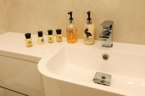 a bathroom sink with a bunch of bottles on it at The Blue Bell Inn in Kettlewell