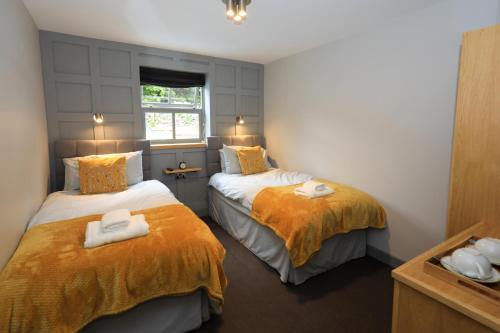 a bedroom with two beds with towels on them at The Blue Bell Inn in Kettlewell