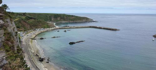 an aerial view of a beach with rocks in the water at Apartamentos Casa Alvarina - Luarca in Cortina